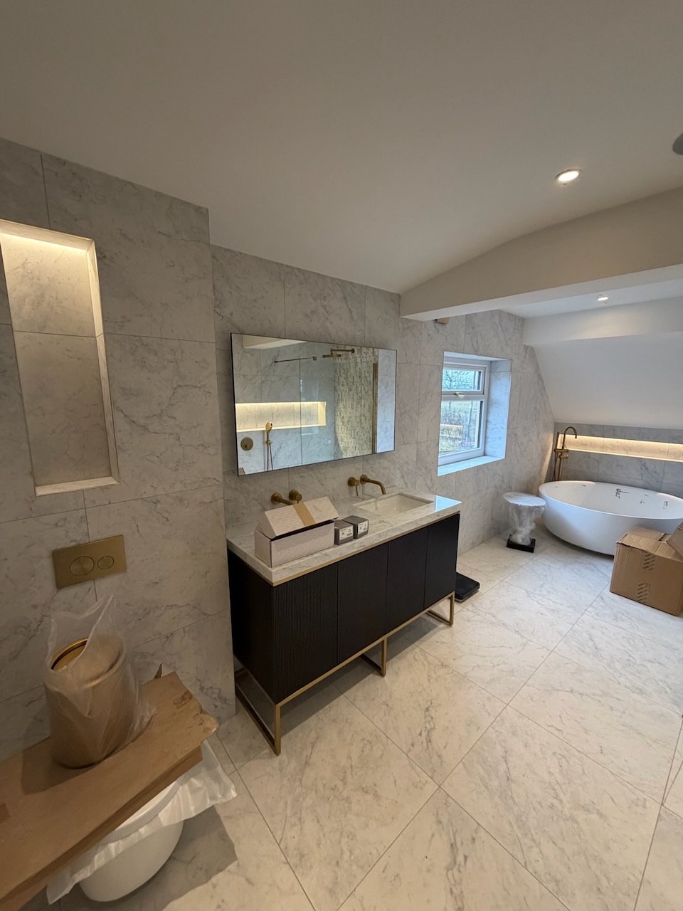 Luxury marble bathroom with double vanity, freestanding bath, and LED-lit niche, Westby, Lytham — Wilsons Systems